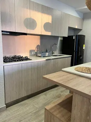 a kitchen with wooden cabinets and a black refrigerator at DQ505 Nuevo hermoso jacuzzi priv in Cartagena de Indias