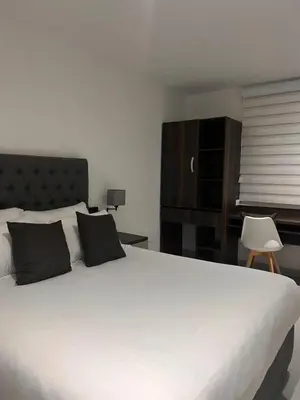 a bedroom with a large white bed with black pillows at Hotel Zuriel Boutique in Cartagena de Indias