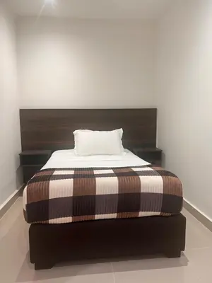 a bed with a brown and white blanket on it at Hotel Zuriel Boutique in Cartagena de Indias