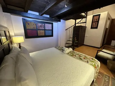 a bedroom with a bed and a couch in a room at Hotel Boutique Casa Córdoba Estrella in Cartagena de Indias