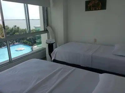 two beds in a room with a view of a pool at Costa Azul Suites 63 in Playa Dormida