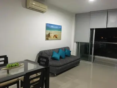 a living room with a couch with blue pillows at Costa Azul Suites 63 in Playa Dormida