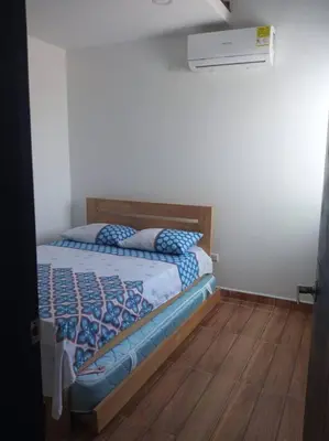a bedroom with a bed with a wooden floor at Apto en Coveñas cerca al mar in Coveñas