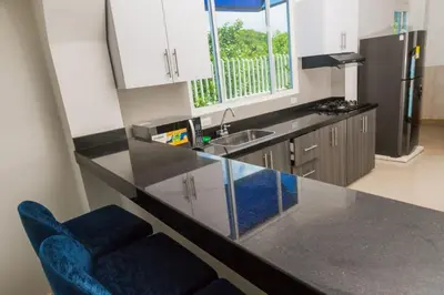 a kitchen with a counter and a blue chair in it at Beach cabin near Barranquilla in Santa Veronica