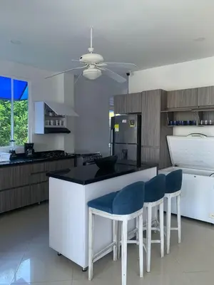 a kitchen with a island with blue chairs in it at Beach cabin near Barranquilla in Santa Veronica