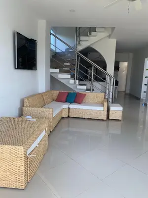 a living room with two couches and a staircase at Beach cabin near Barranquilla in Santa Veronica