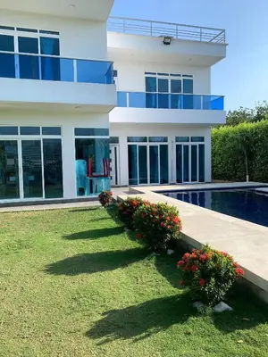 a house with a swimming pool in front of it at Beach cabin near Barranquilla in Santa Veronica