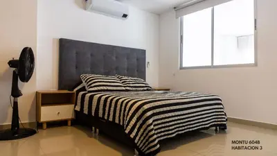 a bedroom with a bed with a black and white blanket at Espectacular Duplex con vista al mar in Cartagena de Indias