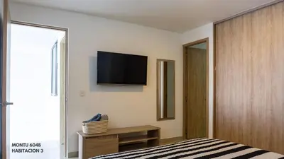 a bedroom with a bed and a television on the wall at Espectacular Duplex con vista al mar in Cartagena de Indias