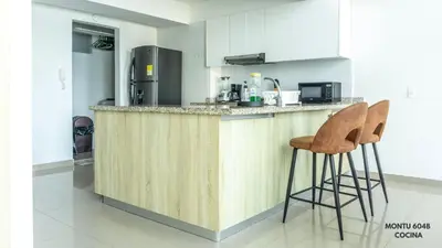 a kitchen with a counter and two stools at Espectacular Duplex con vista al mar in Cartagena de Indias
