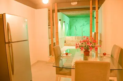 a dining room with a glass table and a refrigerator at Casa Acogedora con Piscina - House Rouse 14 in Cartagena de Indias