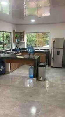 a large kitchen with a desk and a refrigerator at San Antero Cabaña de Oro in San Antero