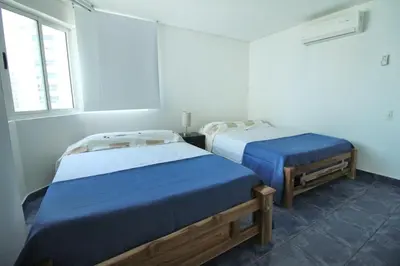a room with two beds and a window at Apartamento de 3 habitaciones, 1103 in Cartagena de Indias