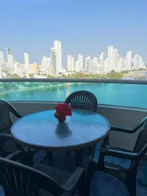 a table with a red flower on top of a balcony at Apartamento de 3 habitaciones, 1103 in Cartagena de Indias