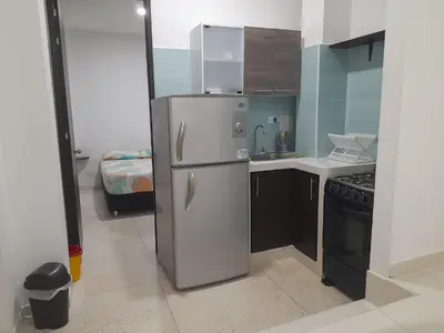 a kitchen with a stainless steel refrigerator and a stove at Apartaestudio Cartagena 4P in Cartagena de Indias