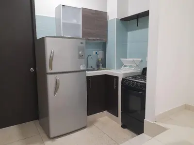 a small kitchen with a refrigerator and a stove at Apartaestudio Cartagena 4P in Cartagena de Indias