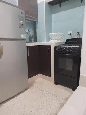 a kitchen with a black stove and a refrigerator at Apartaestudio Cartagena 4P in Cartagena de Indias