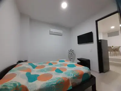 a bedroom with a bed and a flat screen tv at Apartaestudio Cartagena 4P in Cartagena de Indias