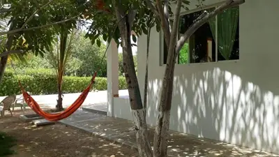 a hammock between two trees next to a building at Cabaña 2 en la mejor playa de Coveñas in Coveñas