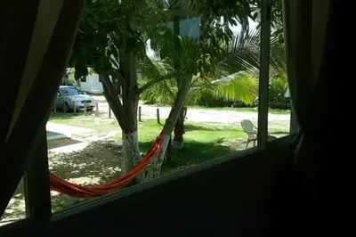 a window with a hammock looking out at a yard at Cabaña 2 en la mejor playa de Coveñas in Coveñas