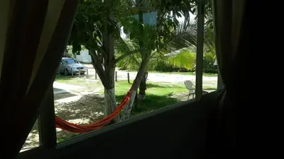 a window with a hammock looking out at a yard at Cabaña 2 en la mejor playa de Coveñas in Coveñas