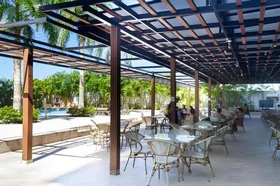 a patio with tables and chairs and a pool at 2 dormitorios Morros. Hidromasaje y Vistas in Cartagena de Indias