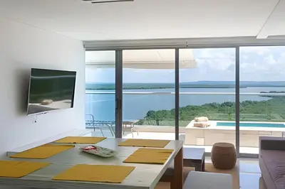 a living room with a table and a view of the water at 2 dormitorios Morros. Hidromasaje y Vistas in Cartagena de Indias