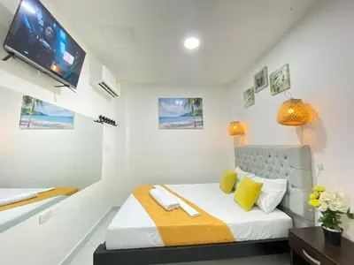 a bedroom with a bed with a tv on the wall at HOTEL HERMOSO CARIBE in Tolú