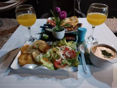 a table with a plate of food and two glasses of orange juice at HOTEL HERMOSO CARIBE in Tolú