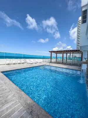 a swimming pool with chairs and a gazebo at Cartagena beach front in Cartagena de Indias