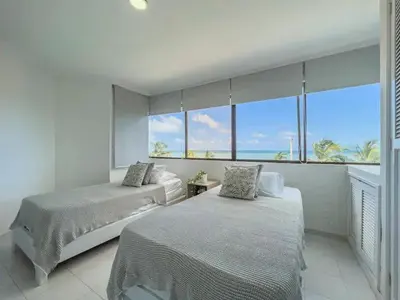 two beds in a bedroom with a view of the ocean at Cartagena beach front in Cartagena de Indias