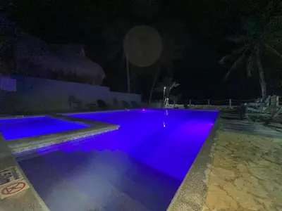 a swimming pool lit up in blue at night at Apartamento en condominio con vista al mar in San Bernardo del Viento