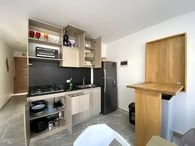 a small kitchen with a refrigerator and a counter at Apartamento en condominio con vista al mar in San Bernardo del Viento