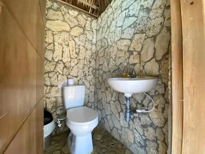 a stone bathroom with a toilet and a sink at Apartamento en condominio con vista al mar in San Bernardo del Viento