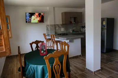 a kitchen with a table and chairs and a tv on the wall at Cabañas en San Antero Bambumar2 in San Antero