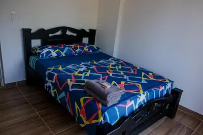 a bedroom with a bed with a colorful comforter at Cabañas en San Antero Bambumar2 in San Antero