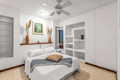 a white bedroom with a bed and a ceiling fan at Beachside Escape 2BR with Pool in Cartagena de Indias