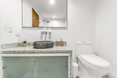 a white bathroom with a toilet and a sink at Beachside Escape 2BR with Pool in Cartagena de Indias