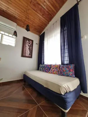 a bedroom with a bed with a blue headboard and a window at Cabaña Amadeus cerca al mar in Coveñas