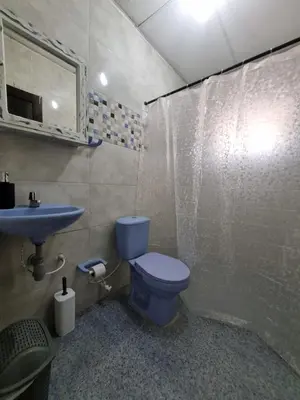 a bathroom with a blue toilet and a sink at Cabaña Amadeus cerca al mar in Coveñas