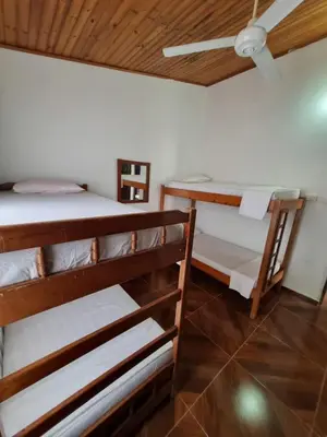 two bunk beds in a room with a ceiling at Cabaña Amadeus cerca al mar in Coveñas
