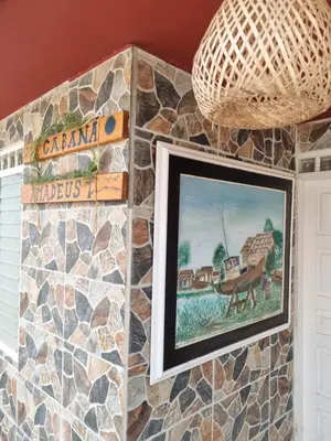 a painting on a wall with a stone wall at Cabaña Amadeus cerca al mar in Coveñas