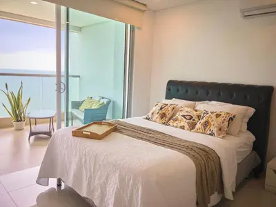a bedroom with a bed with a large window at Sea, Sand & Skyline 30th-Floor Poolside Getaway in Cartagena de Indias