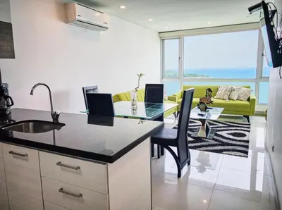 a kitchen and living room with a view of the ocean at Sea, Sand & Skyline 30th-Floor Poolside Getaway in Cartagena de Indias