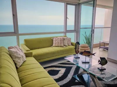 a living room with a yellow couch and a glass table at Sea, Sand & Skyline 30th-Floor Poolside Getaway in Cartagena de Indias