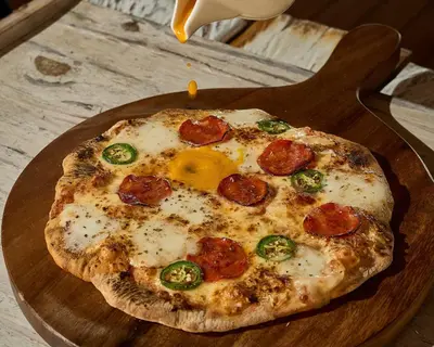a pizza sitting on top of a wooden cutting board at Makani Luxury Cartagena in Tierra Bomba