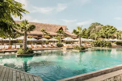 a swimming pool at a resort with chairs and umbrellas at Makani Luxury Cartagena in Tierra Bomba