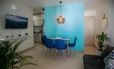a dining room with blue walls and a table and chairs at Apartamento Cielo Cartagena in Cartagena de Indias