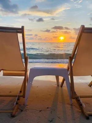 two chairs sitting on the beach with the sunset at Tequila SunBeach Baru Eco-Hotel in Baru
