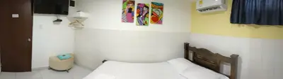 a small bedroom with a bed and a tv at HOSTAL EL ALTISIMO in Cartagena de Indias